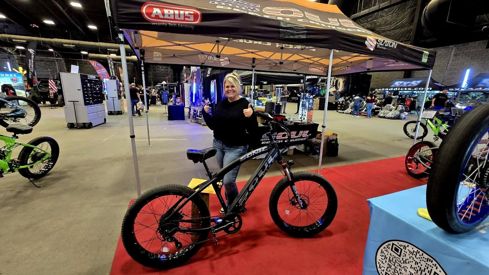 Person posing with bike at an event.