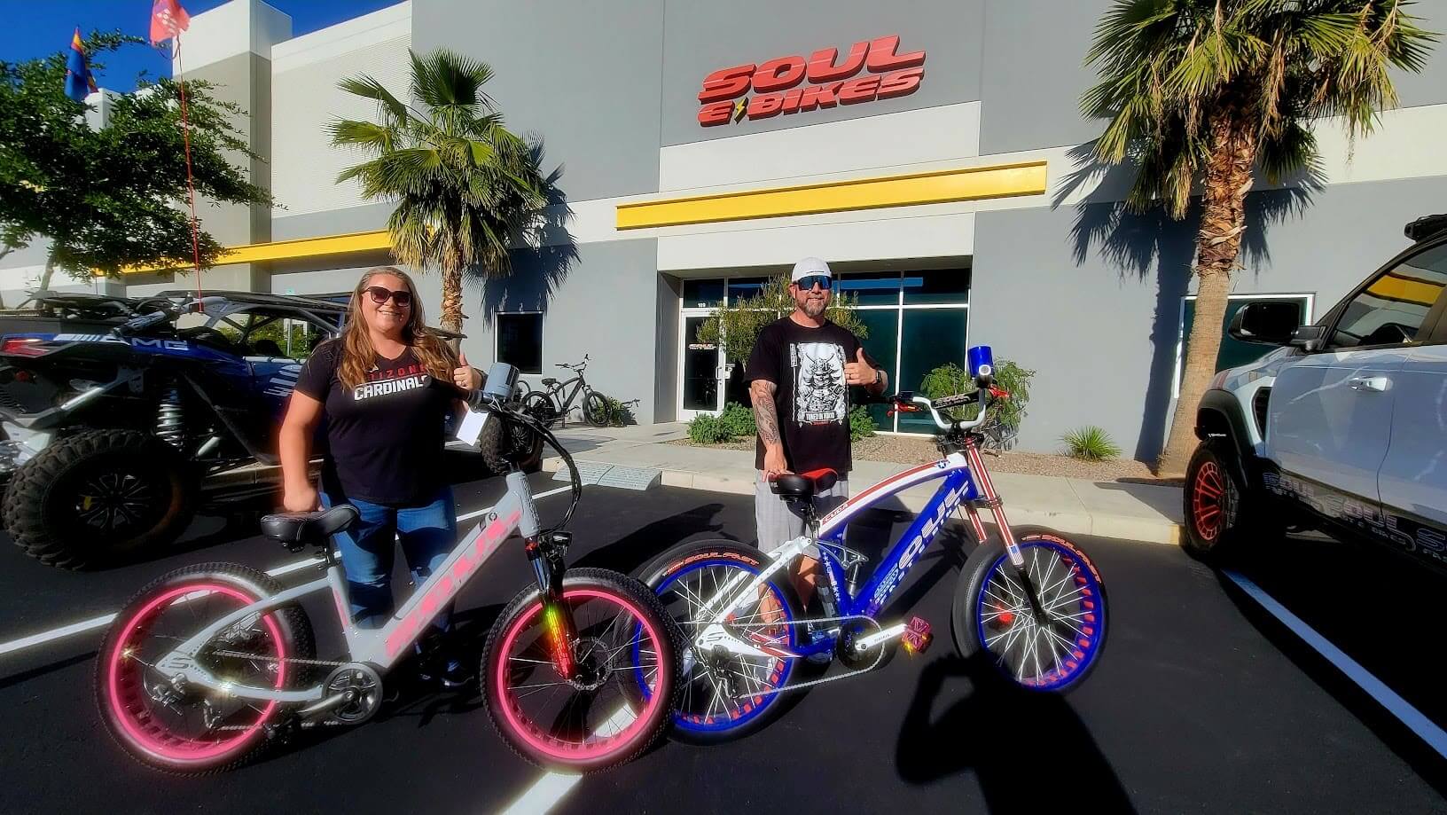 Two people with bikes outside a store.