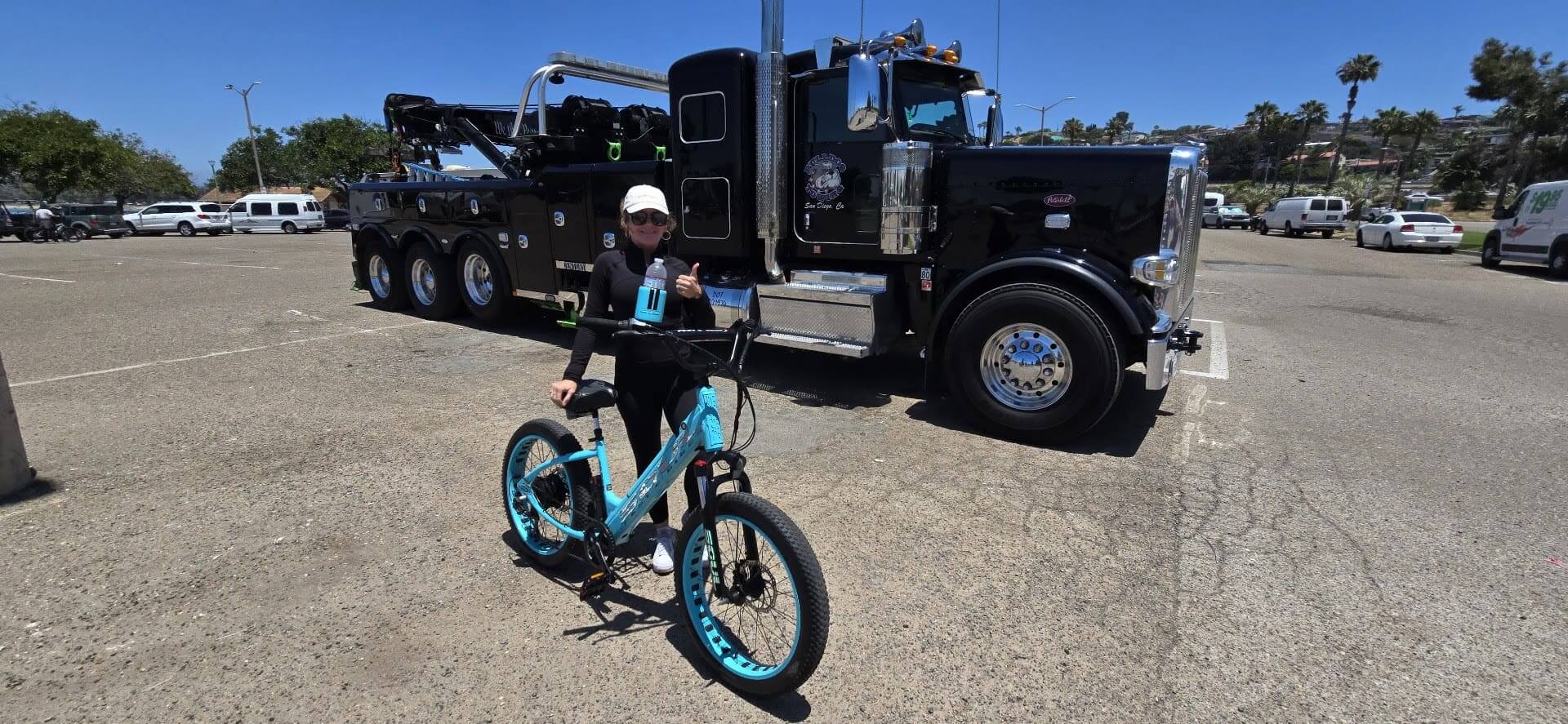 Person with bicycle in front of tow truck.