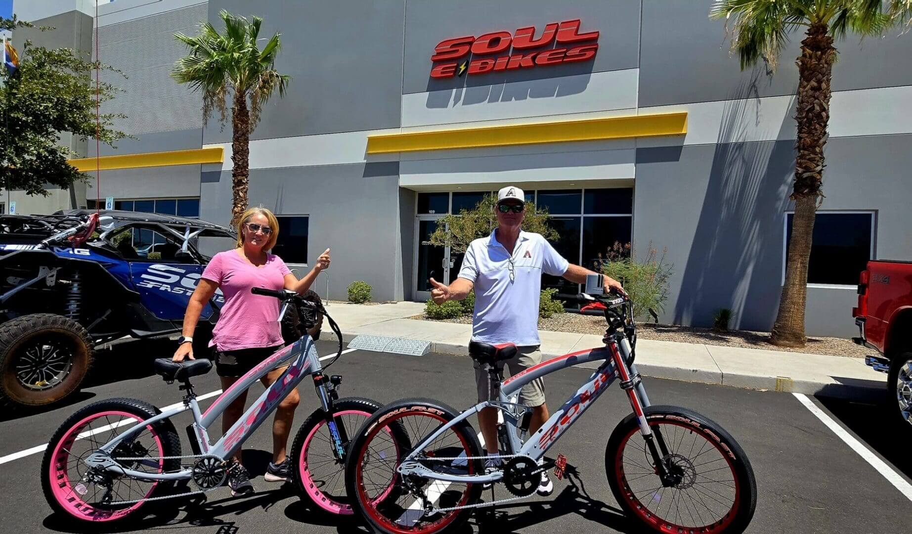 Two people with bikes outside Soul eBikes.