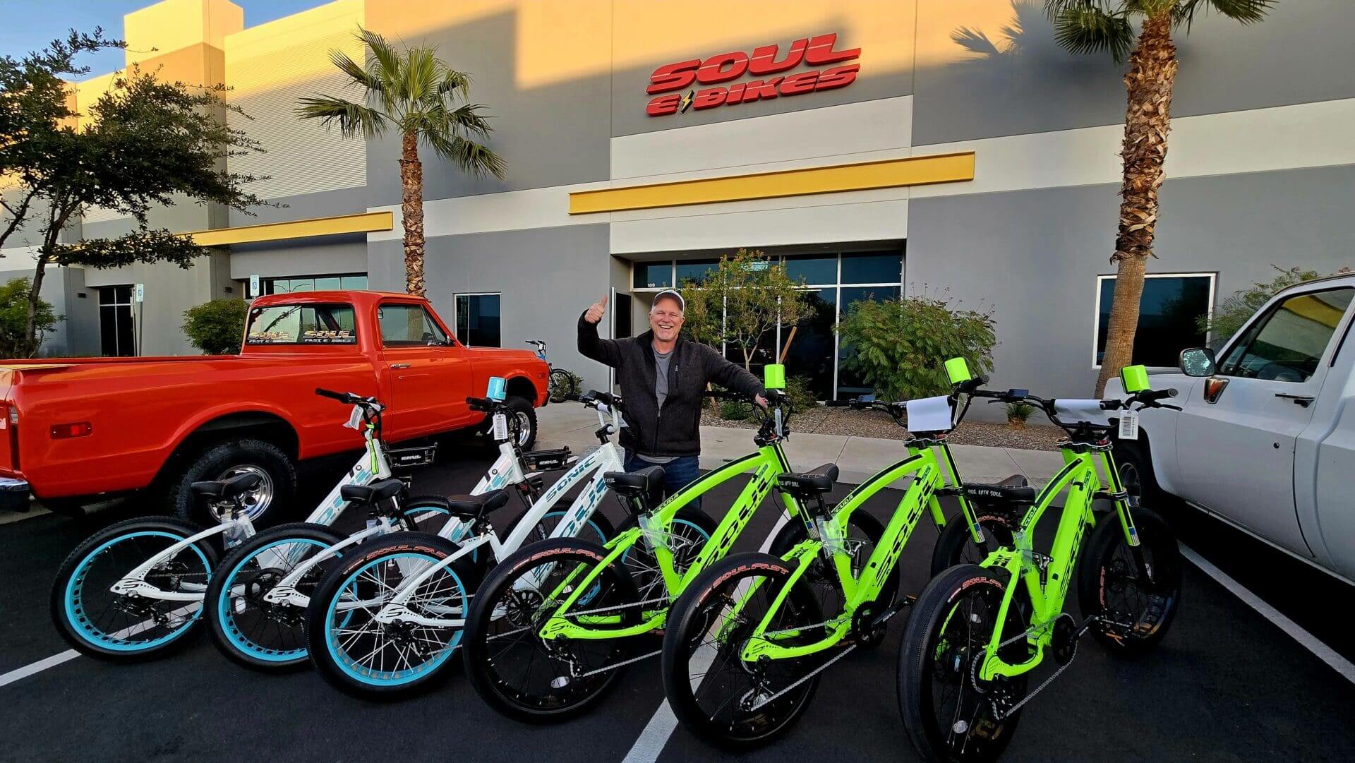 Person with electric bikes outside a store.
