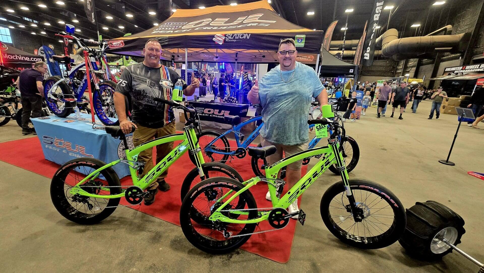 Two people with bright green bicycles indoors.