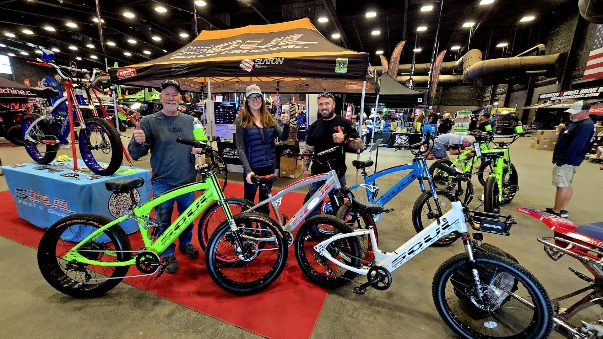 People showcasing colorful bikes at an event.