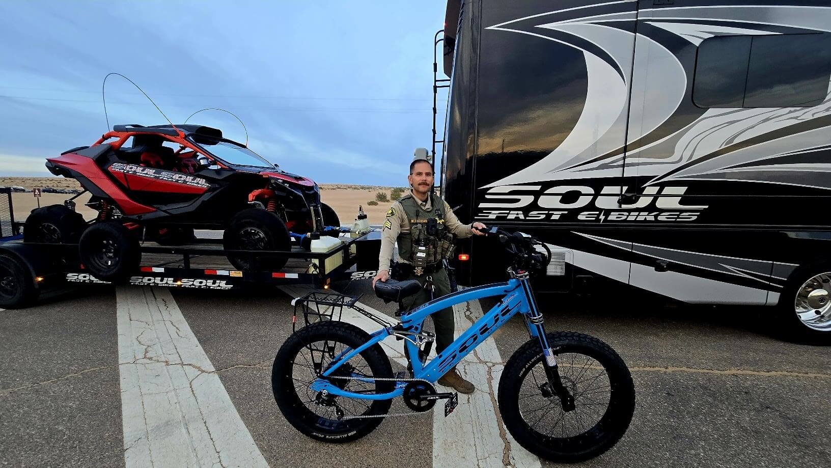 Person with bike beside trailer and RV.