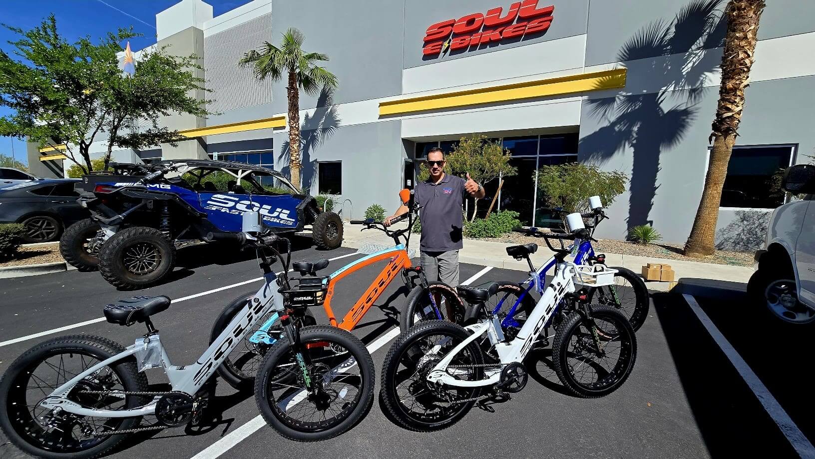 Man with electric bikes outside a store.