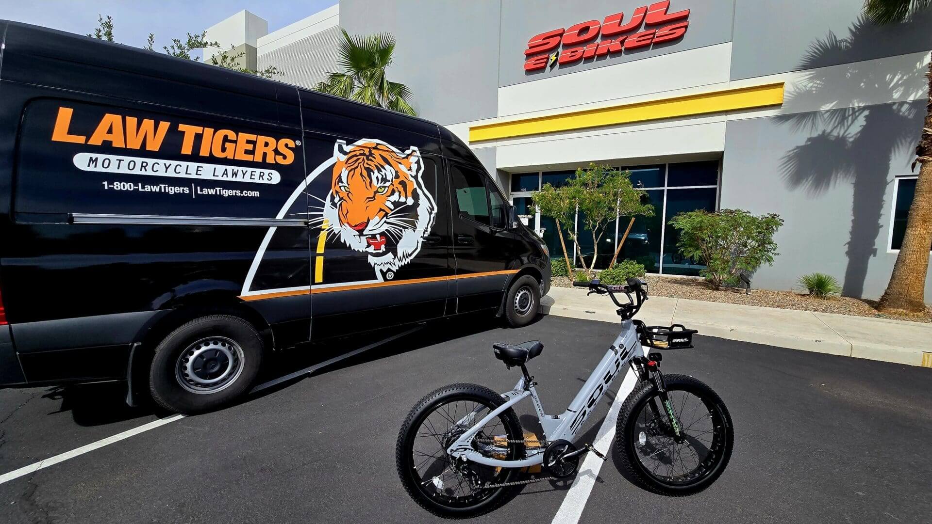 Bicycle parked near van and building entrance.