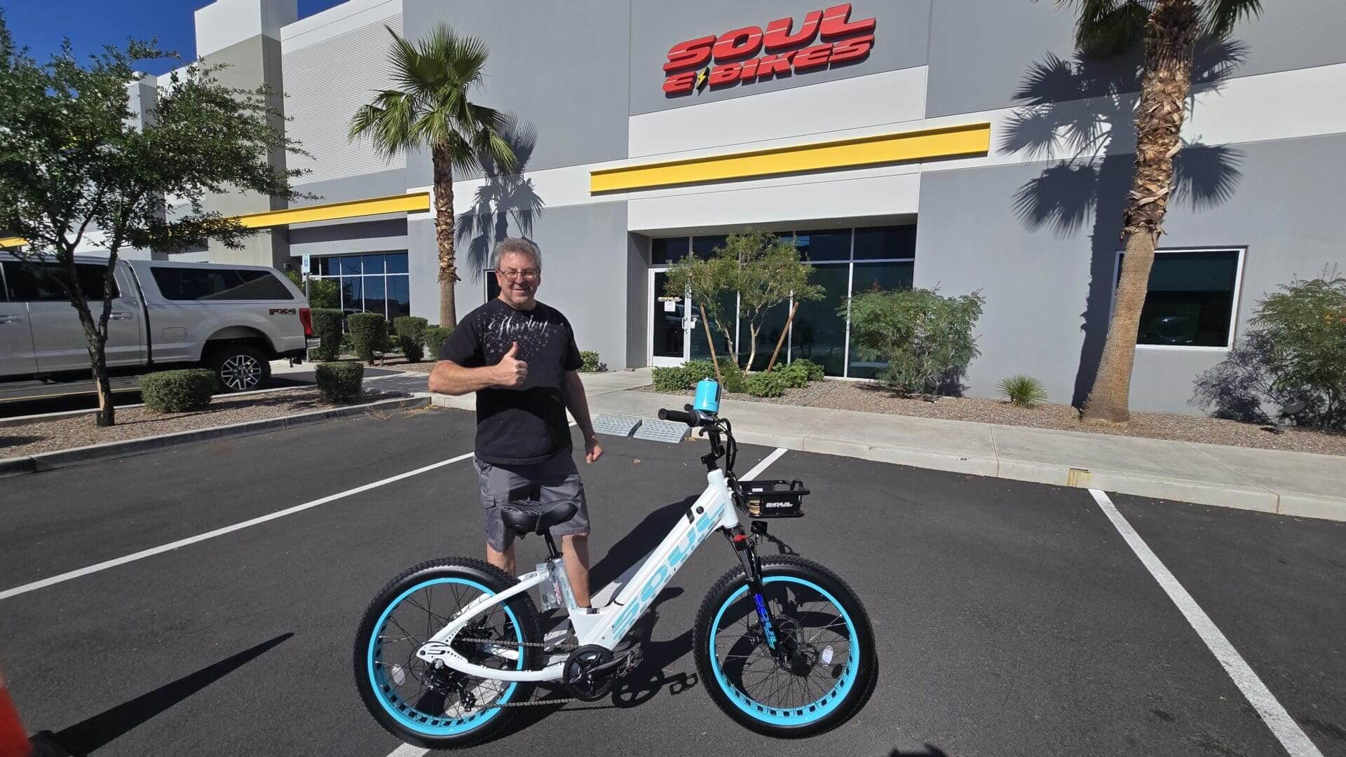 Man with electric bike outside Soul Bikes shop.