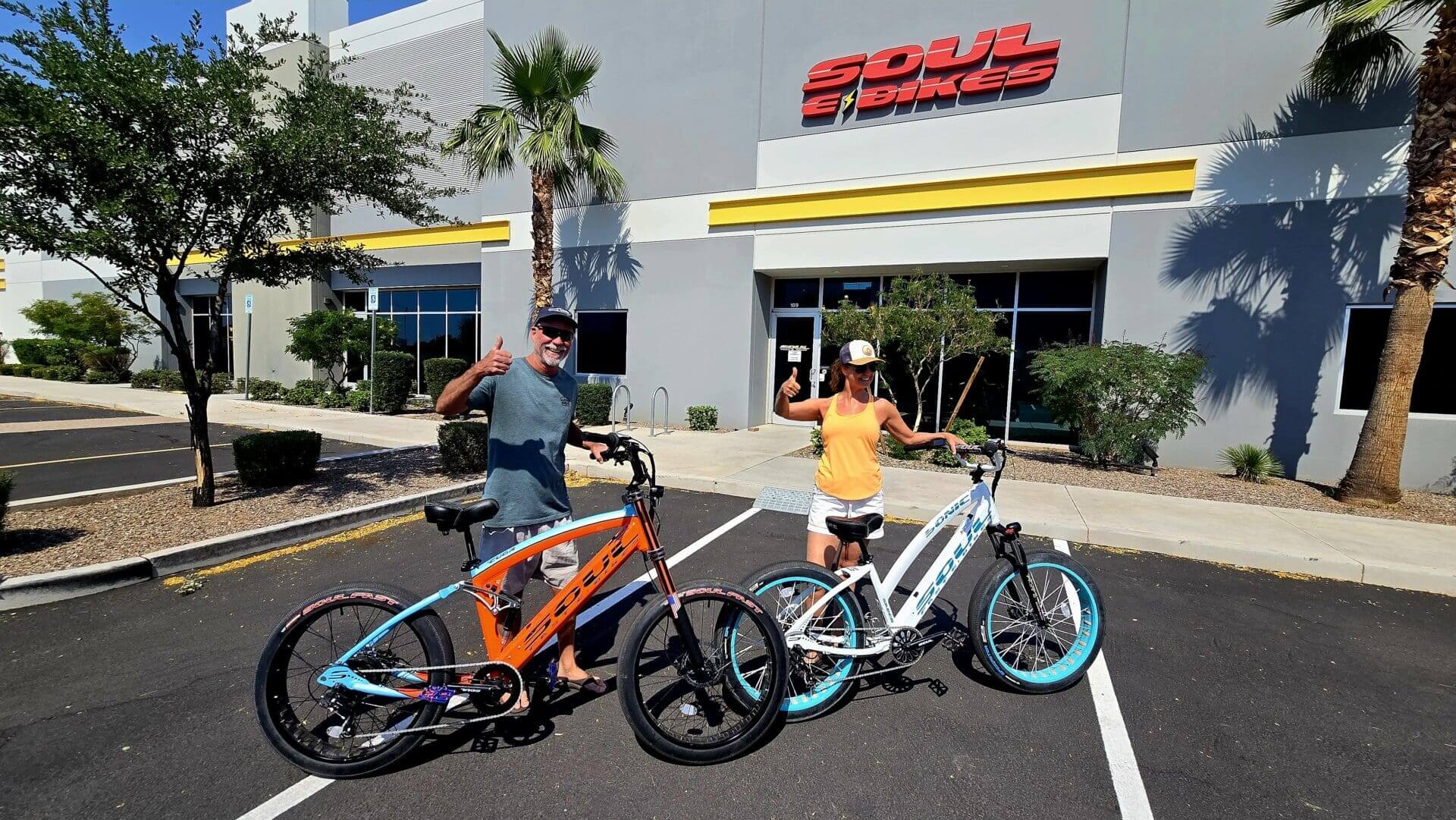 Two people with bikes outside a store.