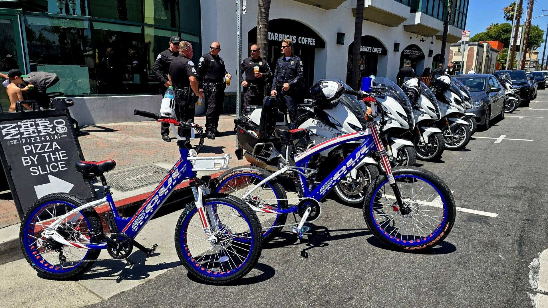Bicycles and motorcycles parked on urban street.