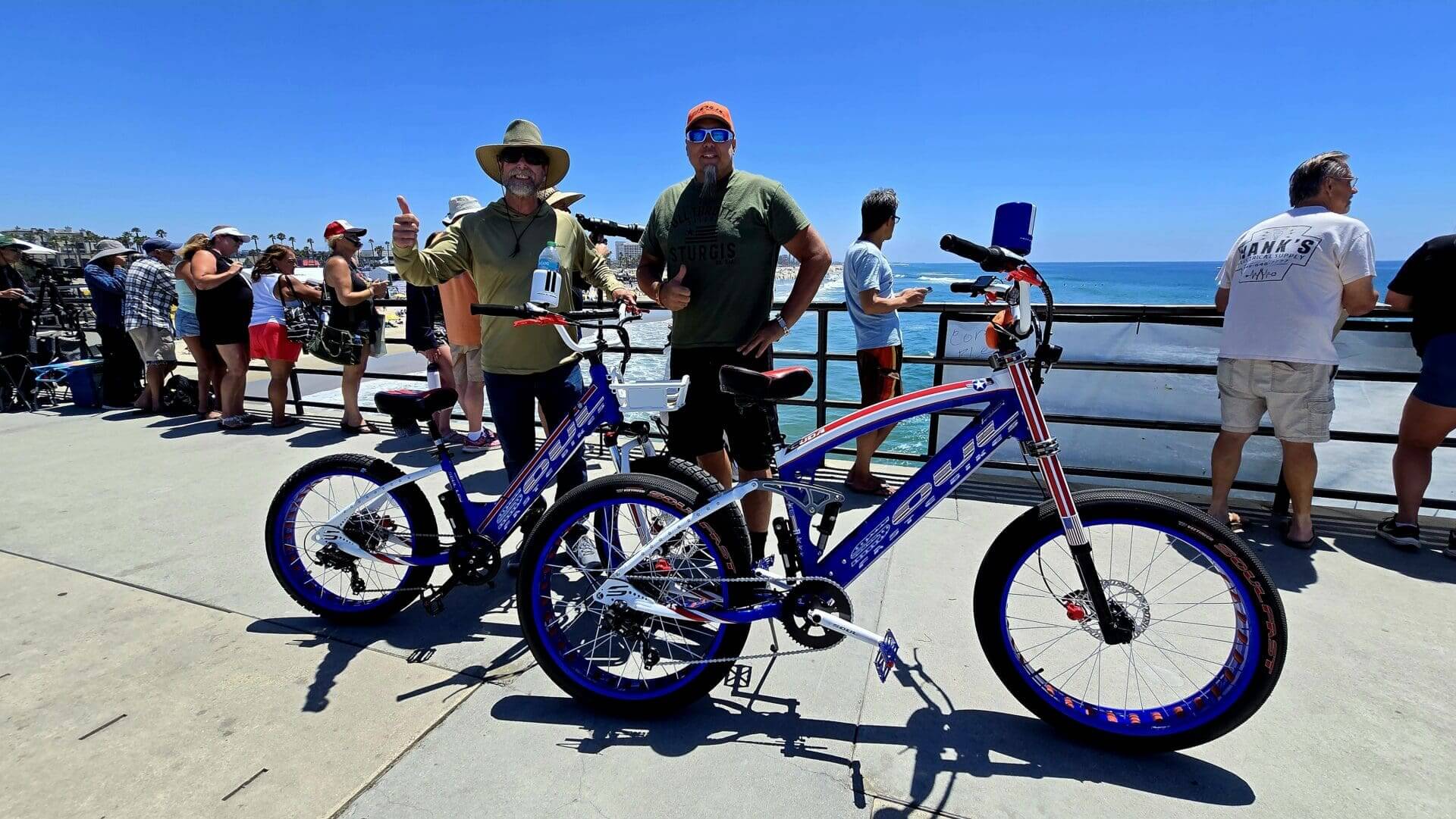 Two people with bikes by the ocean.