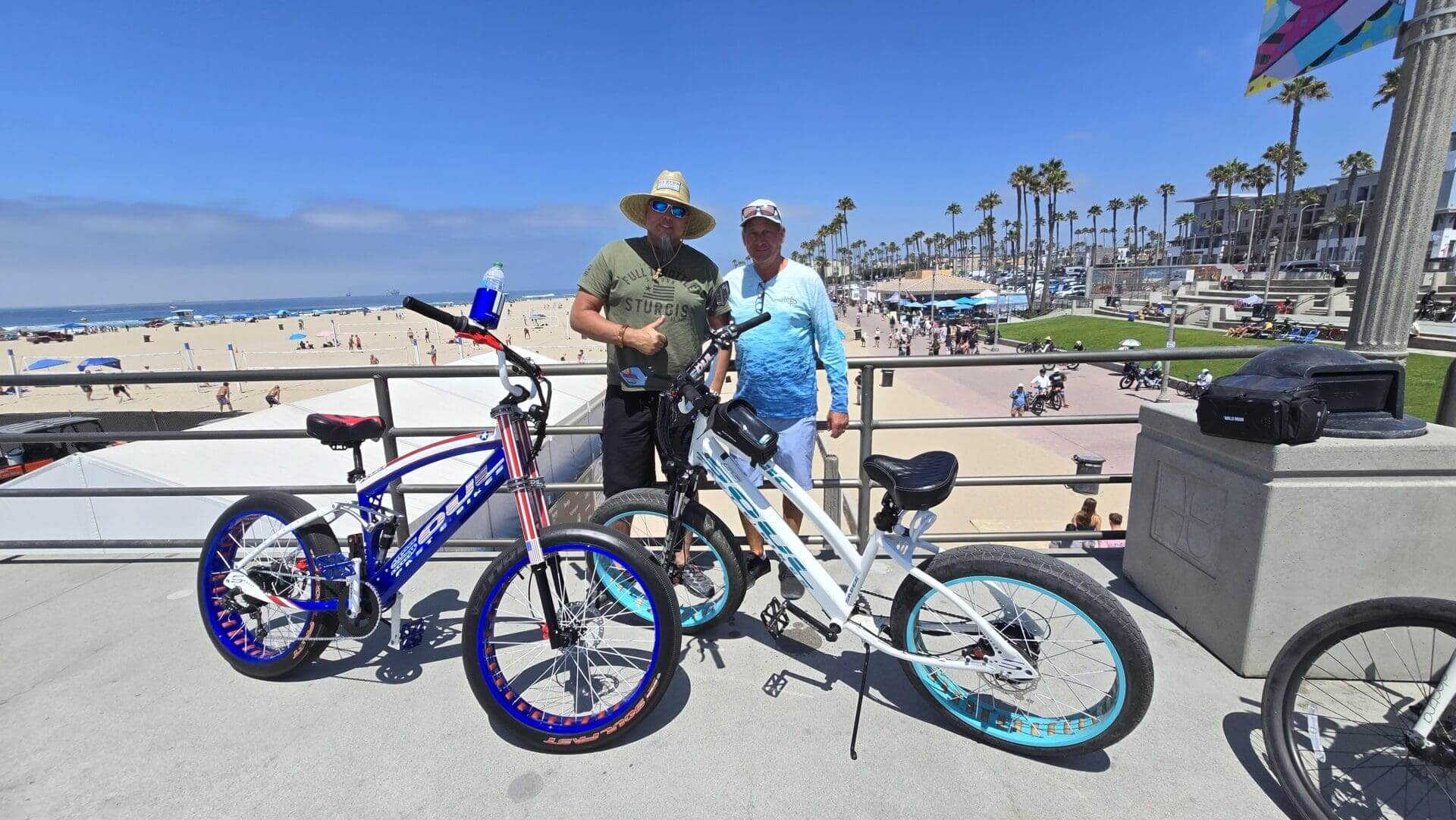 Two people with bikes at the beach.