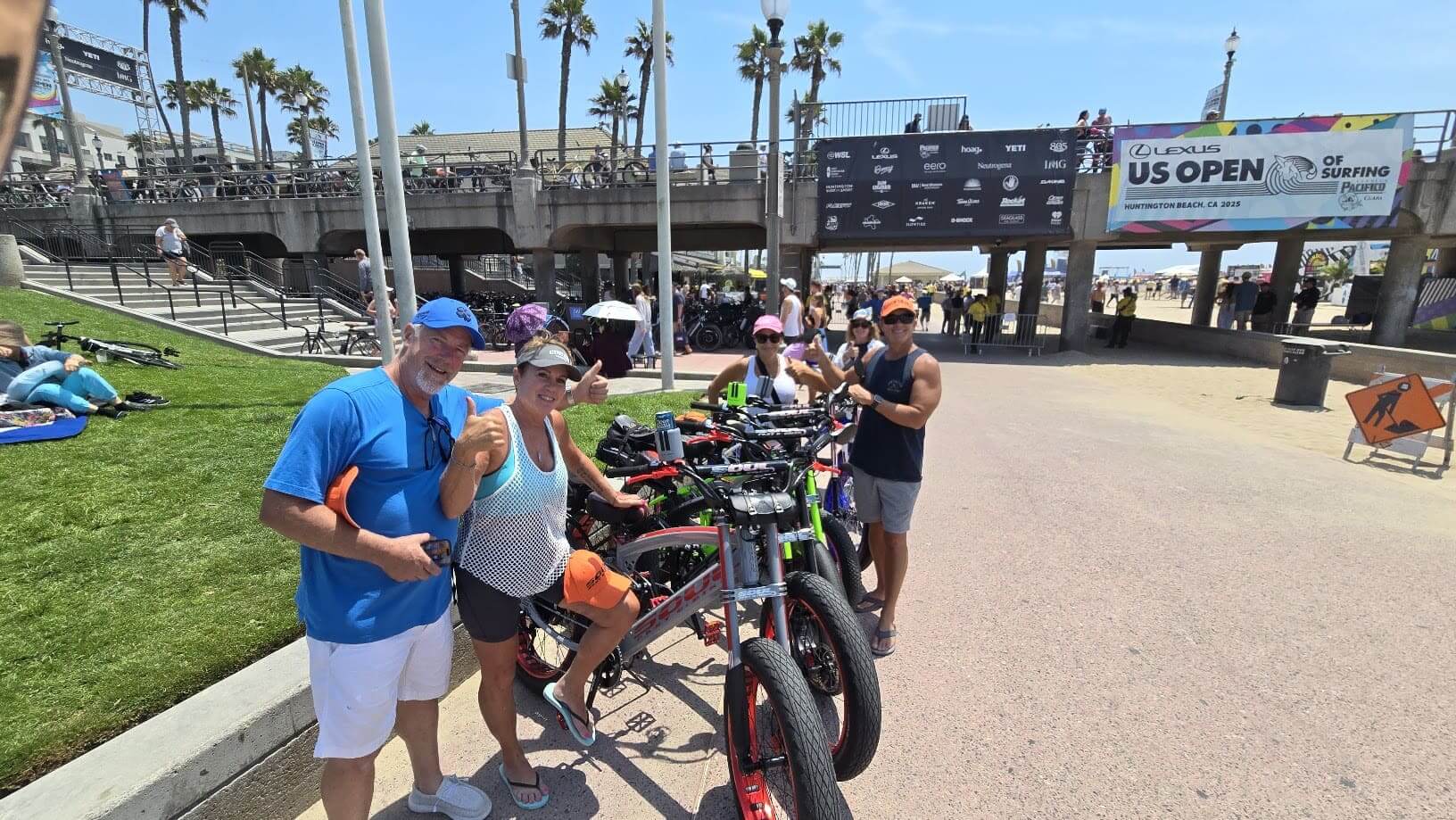 Group posing with bicycles at the beach.