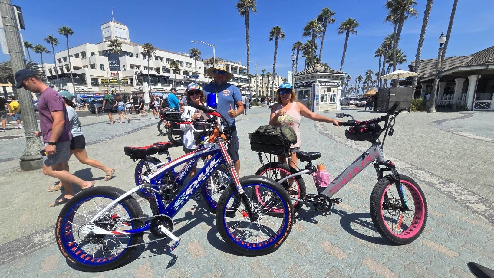 People with bikes at a sunny beach.