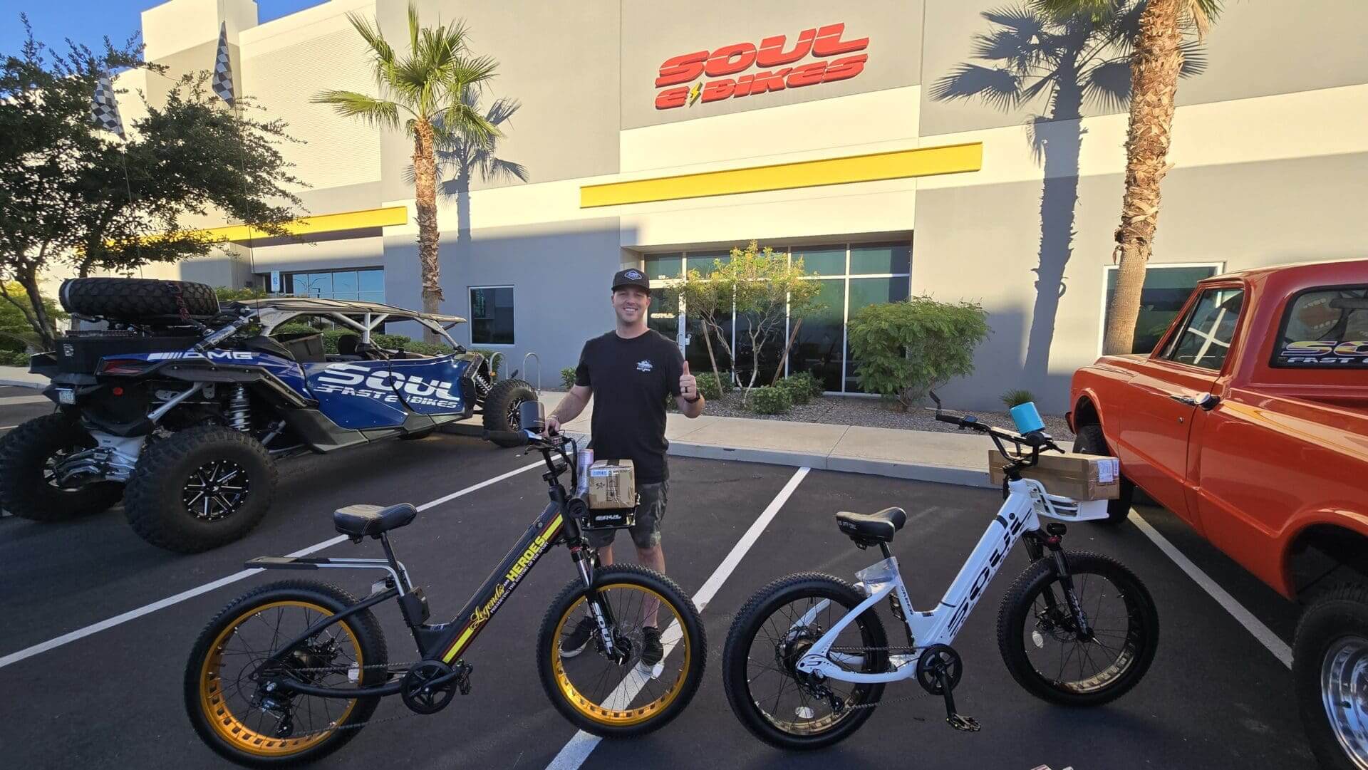 Man with two e-bikes in parking lot.