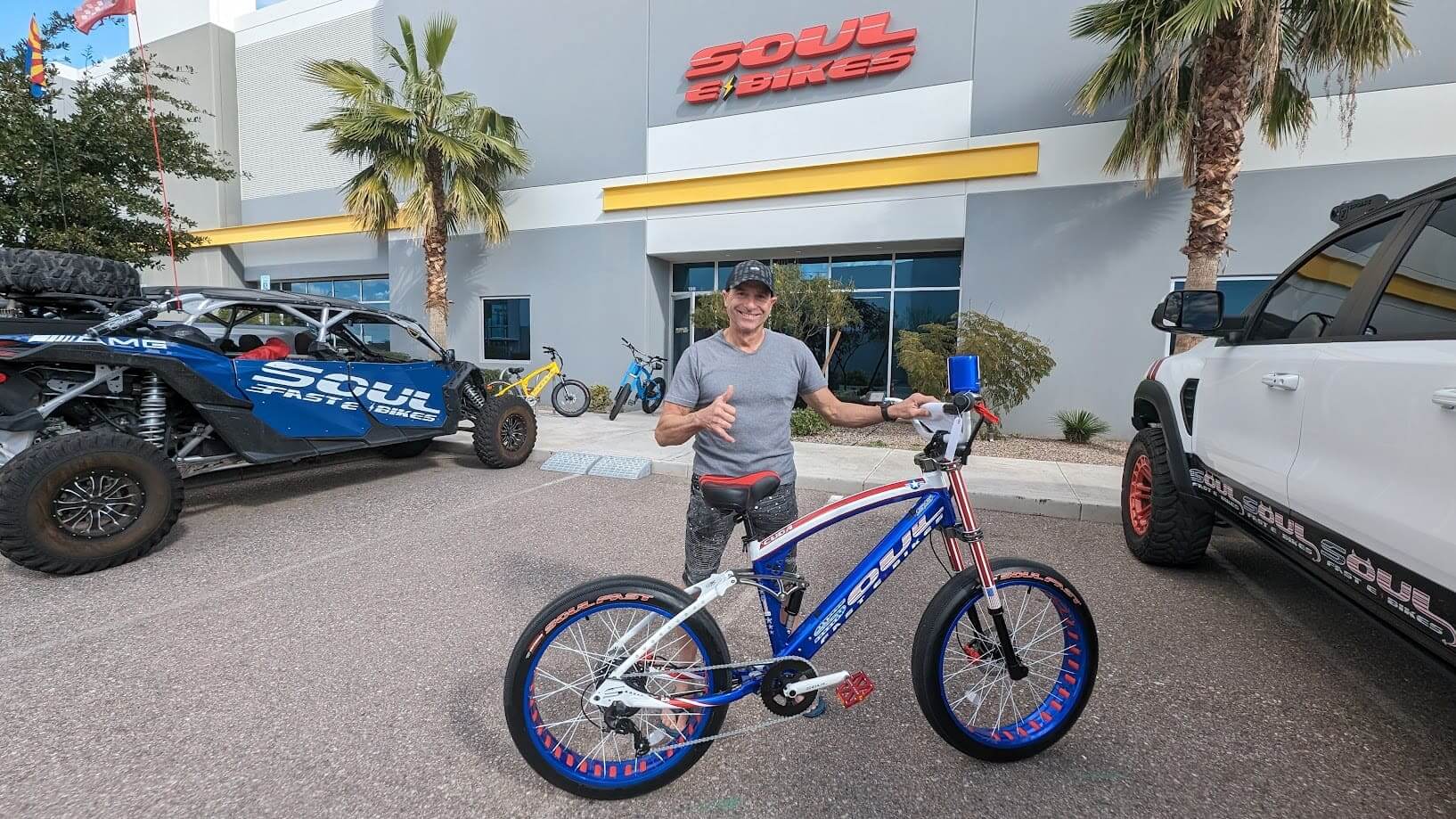 Man posing with electric bike outside store.