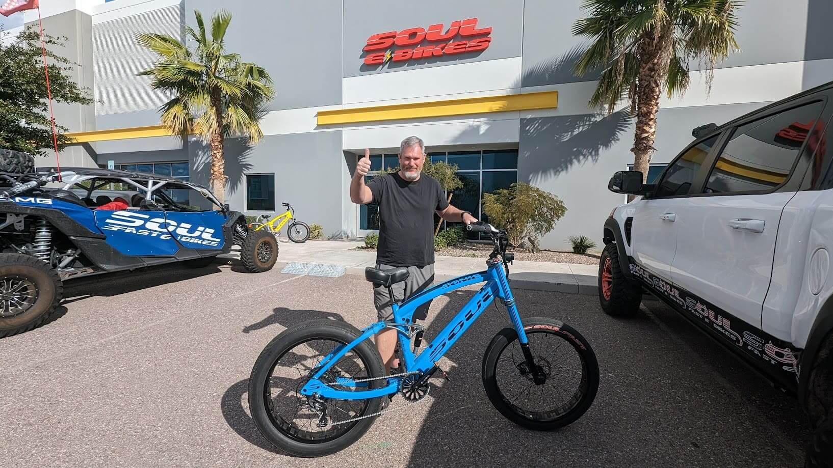 Man with blue bike outside Soul Bikes store.