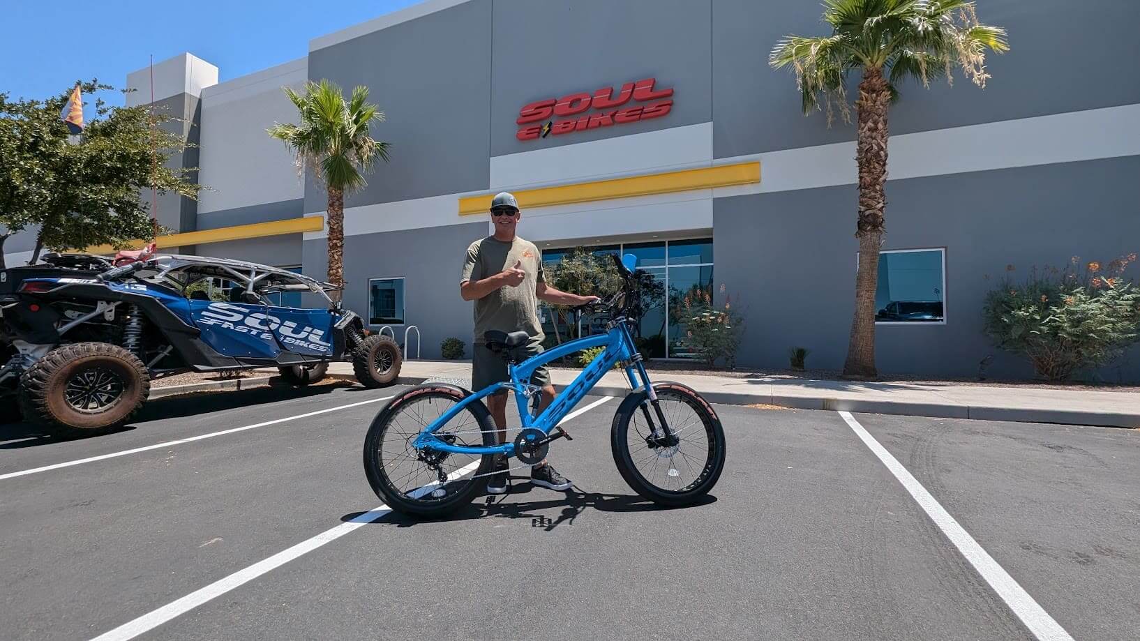 Man with bicycle outside Soul Bicycles store.