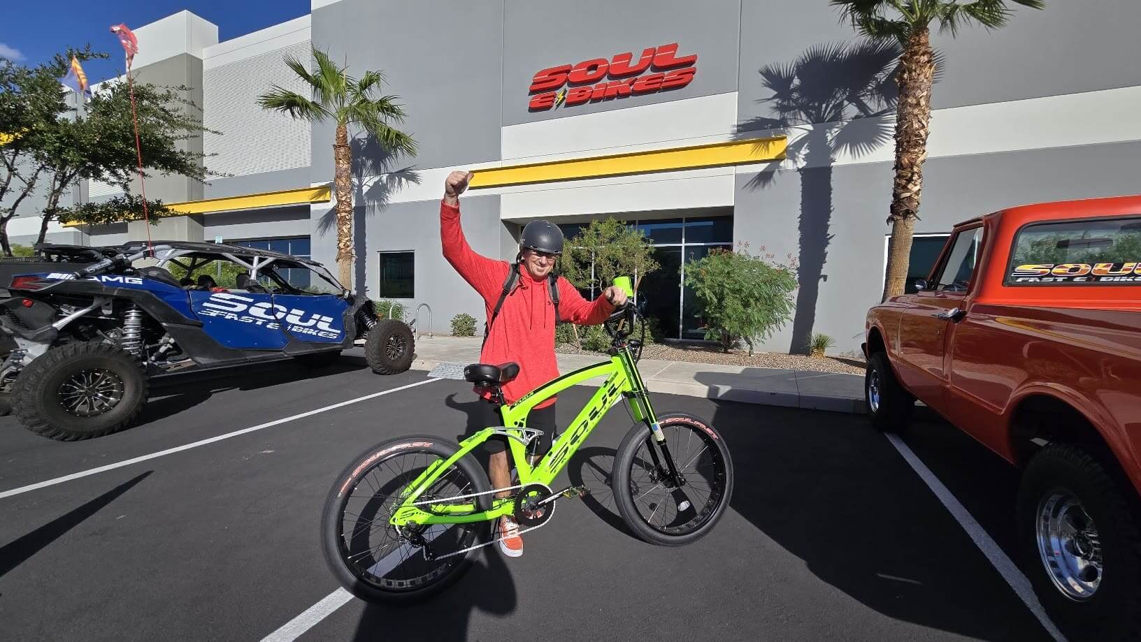 Person with bike outside Soul showroom, cheering.