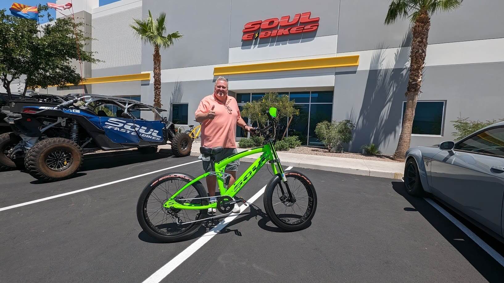 Man with green bike outside Soul Bikes building.
