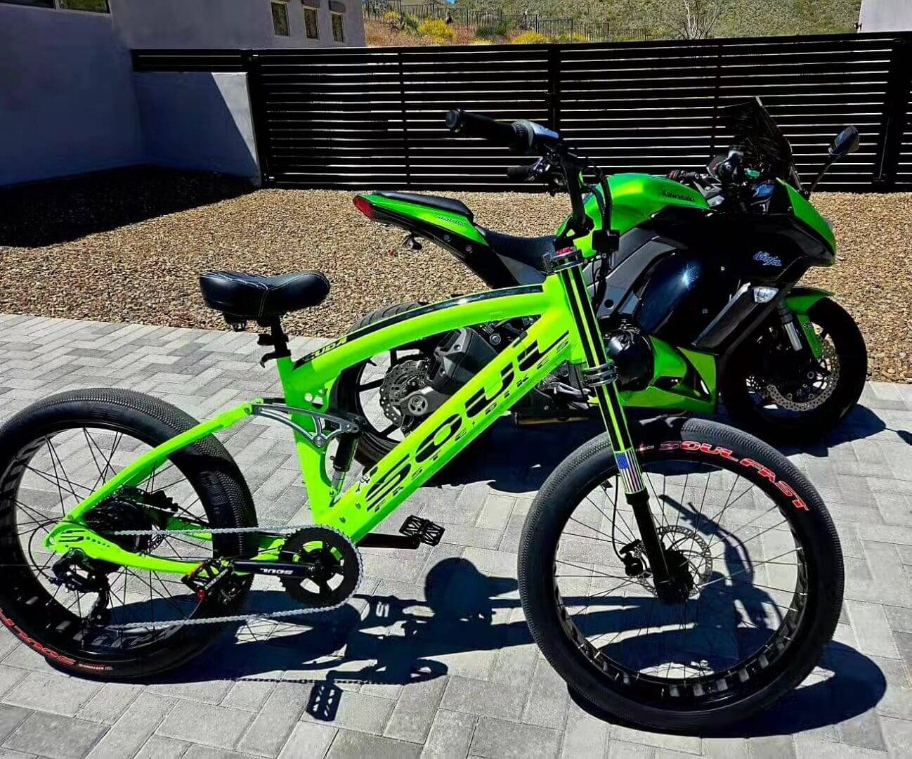 Bright green bicycle and motorcycle parked outside.