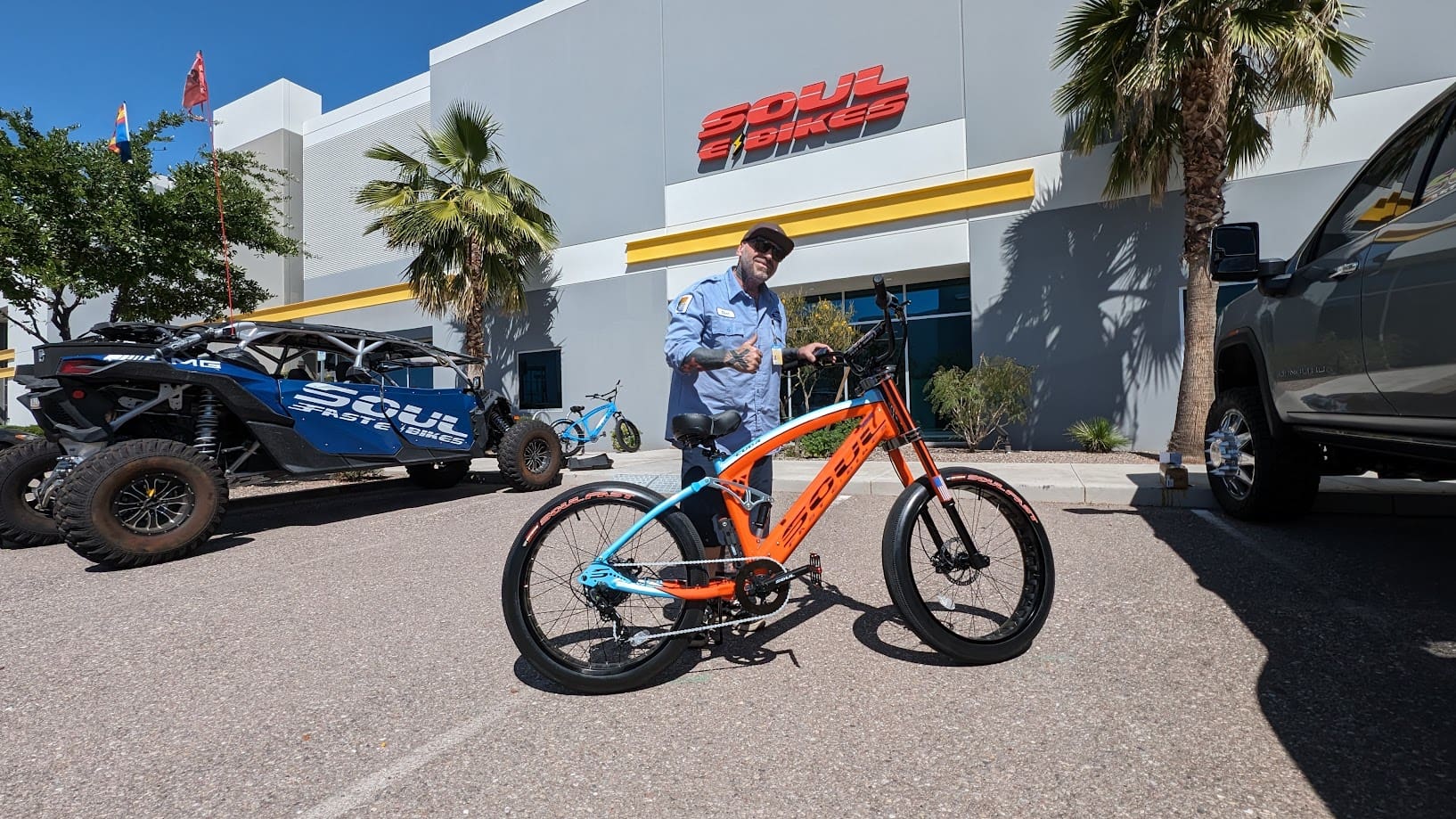 Man standing with electric bicycle outside building.