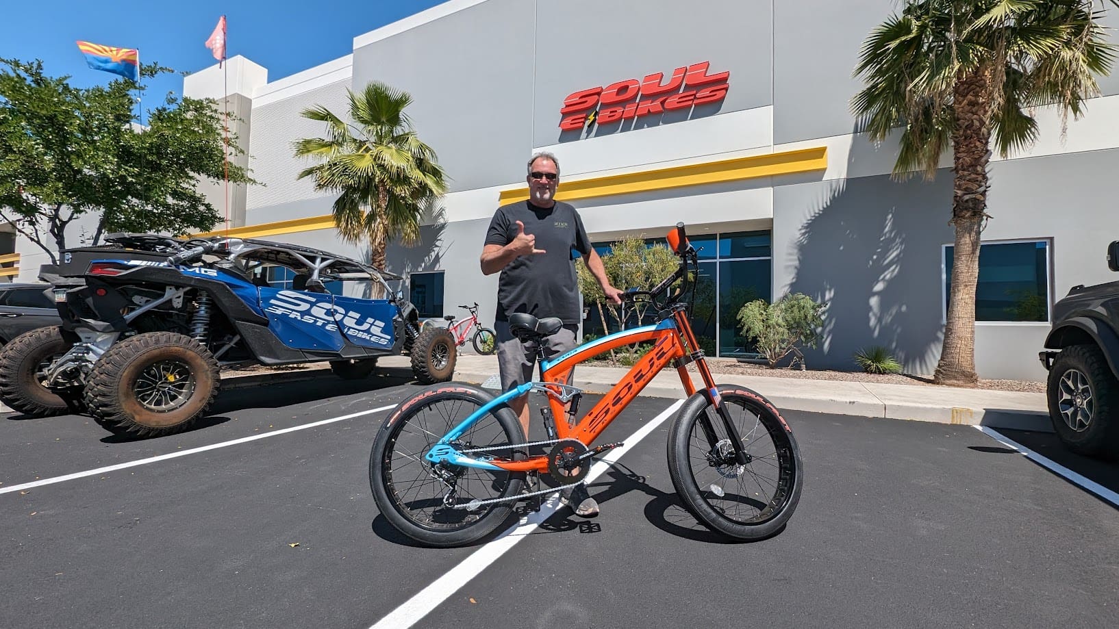 Man with bike outside Soul Beach Cruisers store.