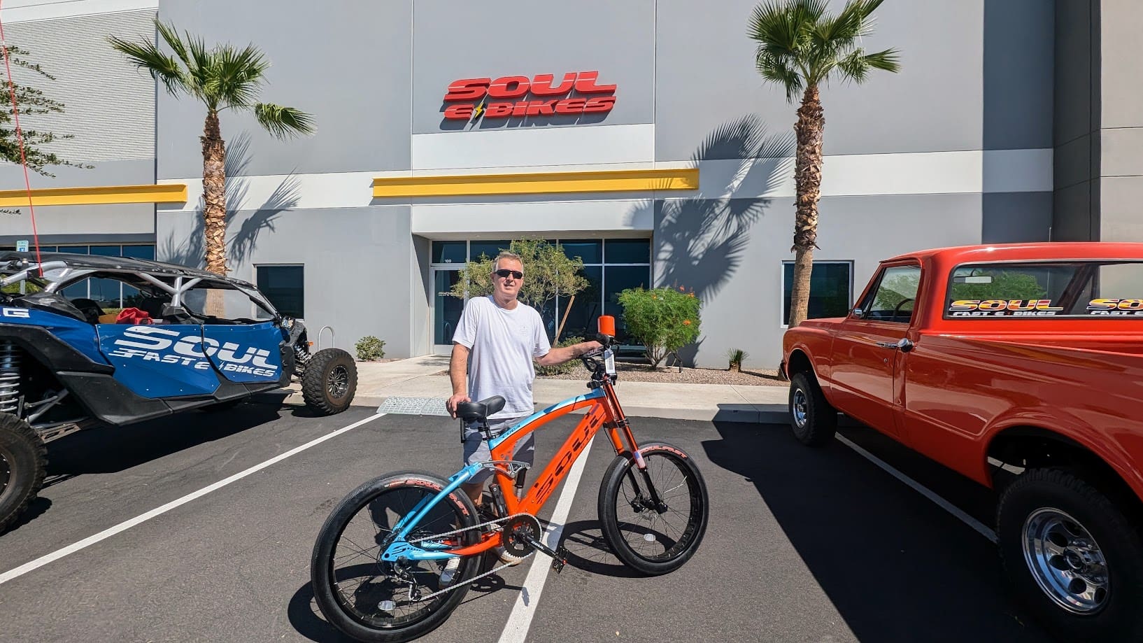 Man with bicycle outside Soul E-Bikes building.