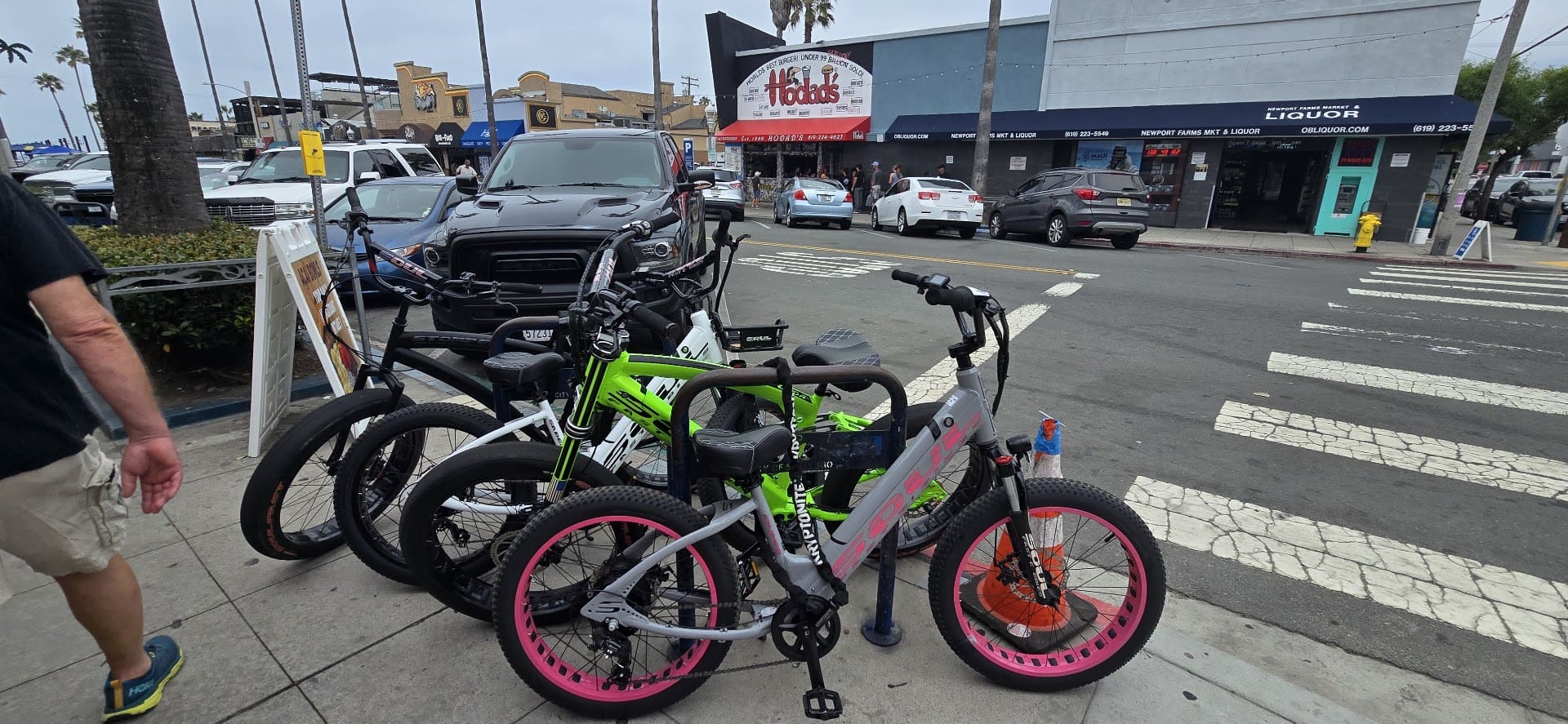 Bicycles parked on city sidewalk near shops.