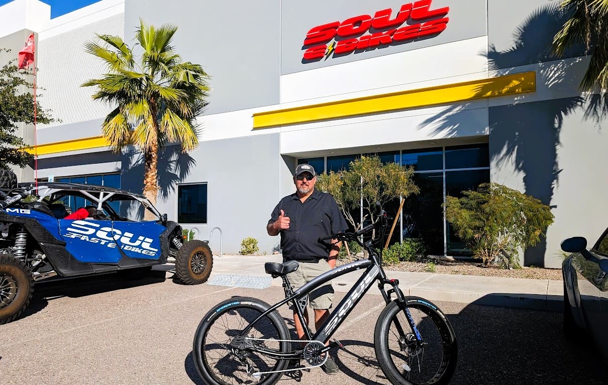 Man with bicycle in front of store.