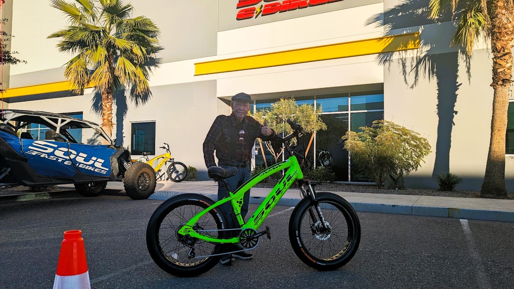 Person with green bike outside building.