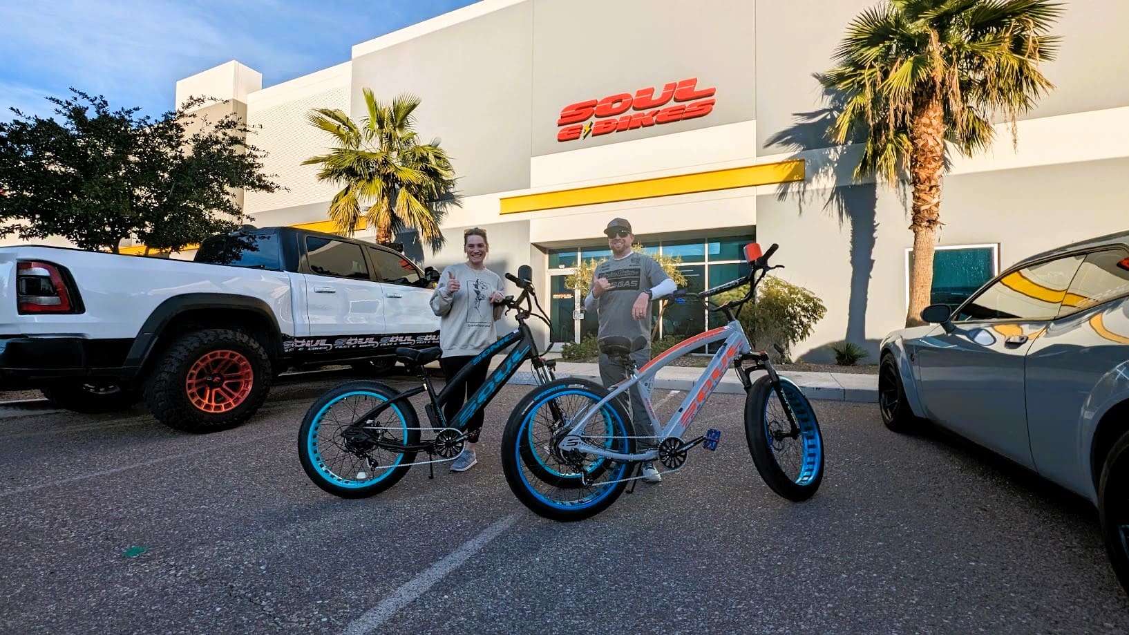 Two people posing with custom bicycles.