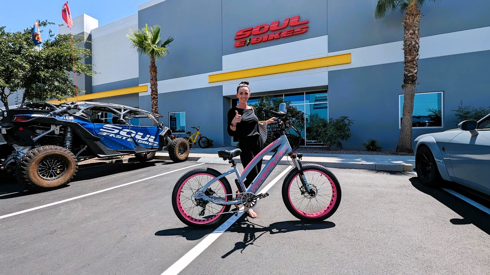 Person with bicycle outside Soul eBikes store.