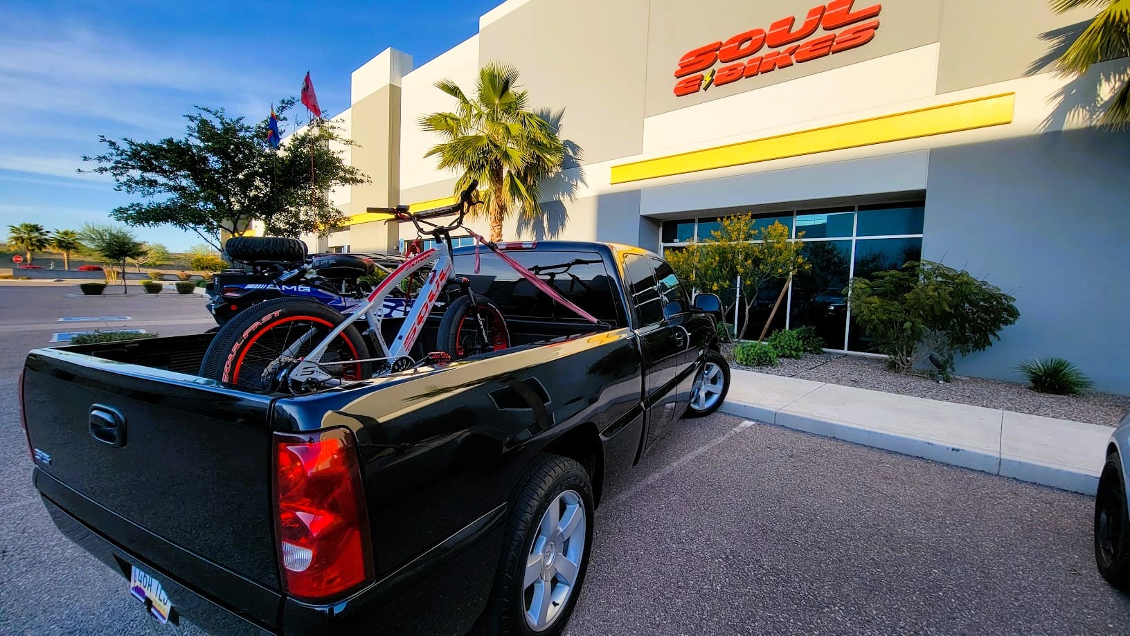 Black truck with bikes outside a store.