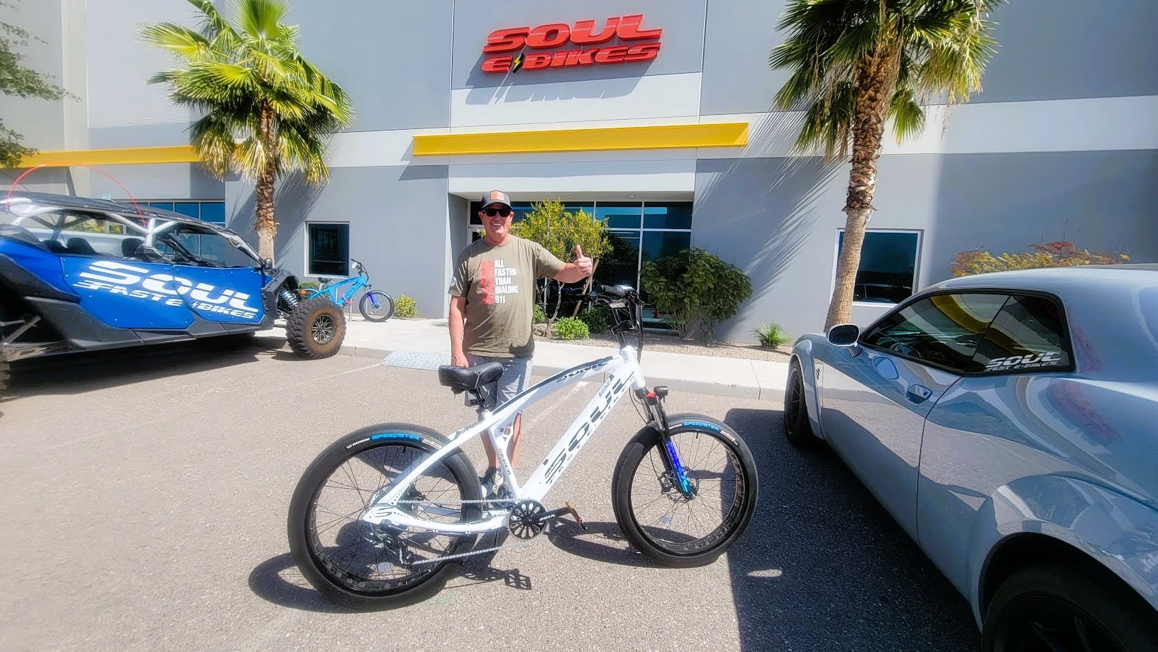Man with bicycle outside Soul E Bikes store.