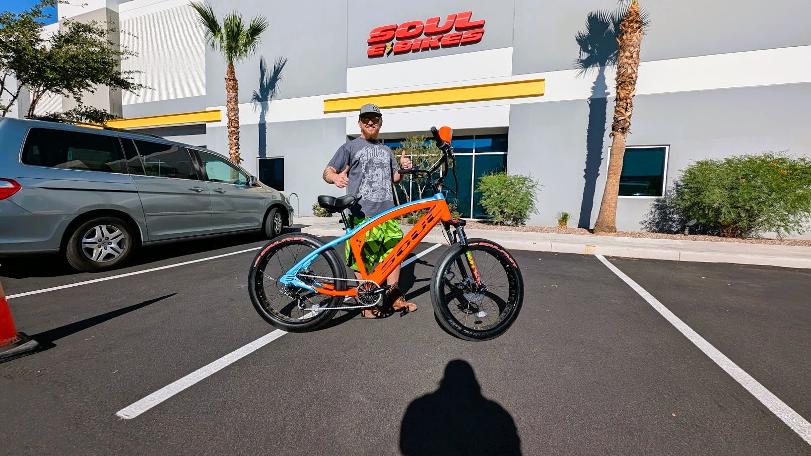 Man with colorful bike outside a building.