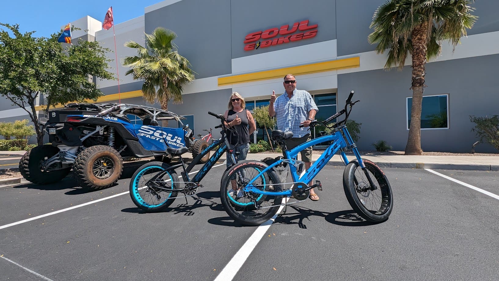 Two people with electric bikes outside building.