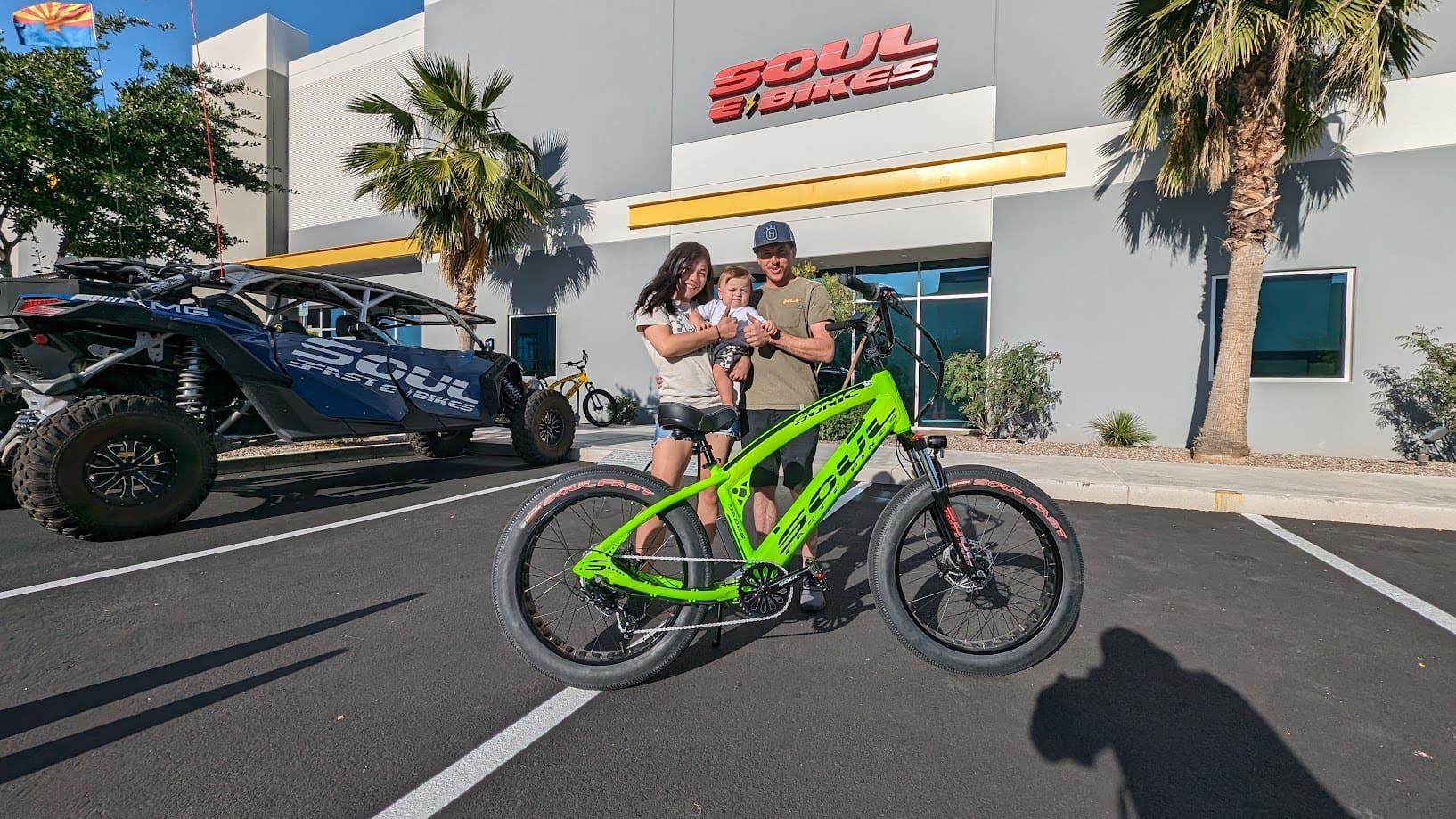 People with a green bike outside building.