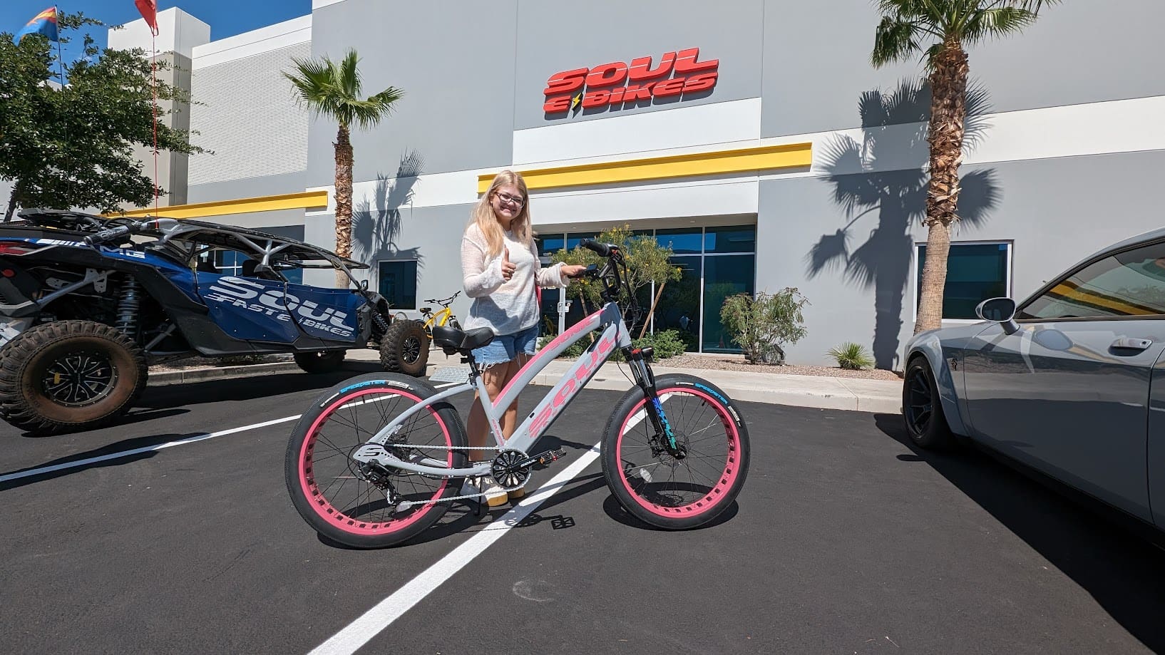 Woman with bicycle outside store building.