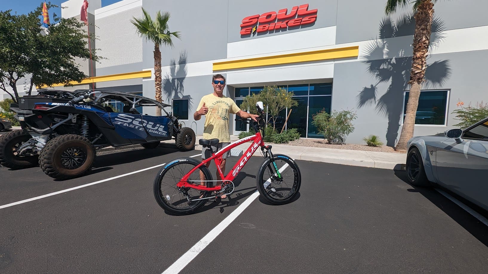 Man with red bike in parking lot.
