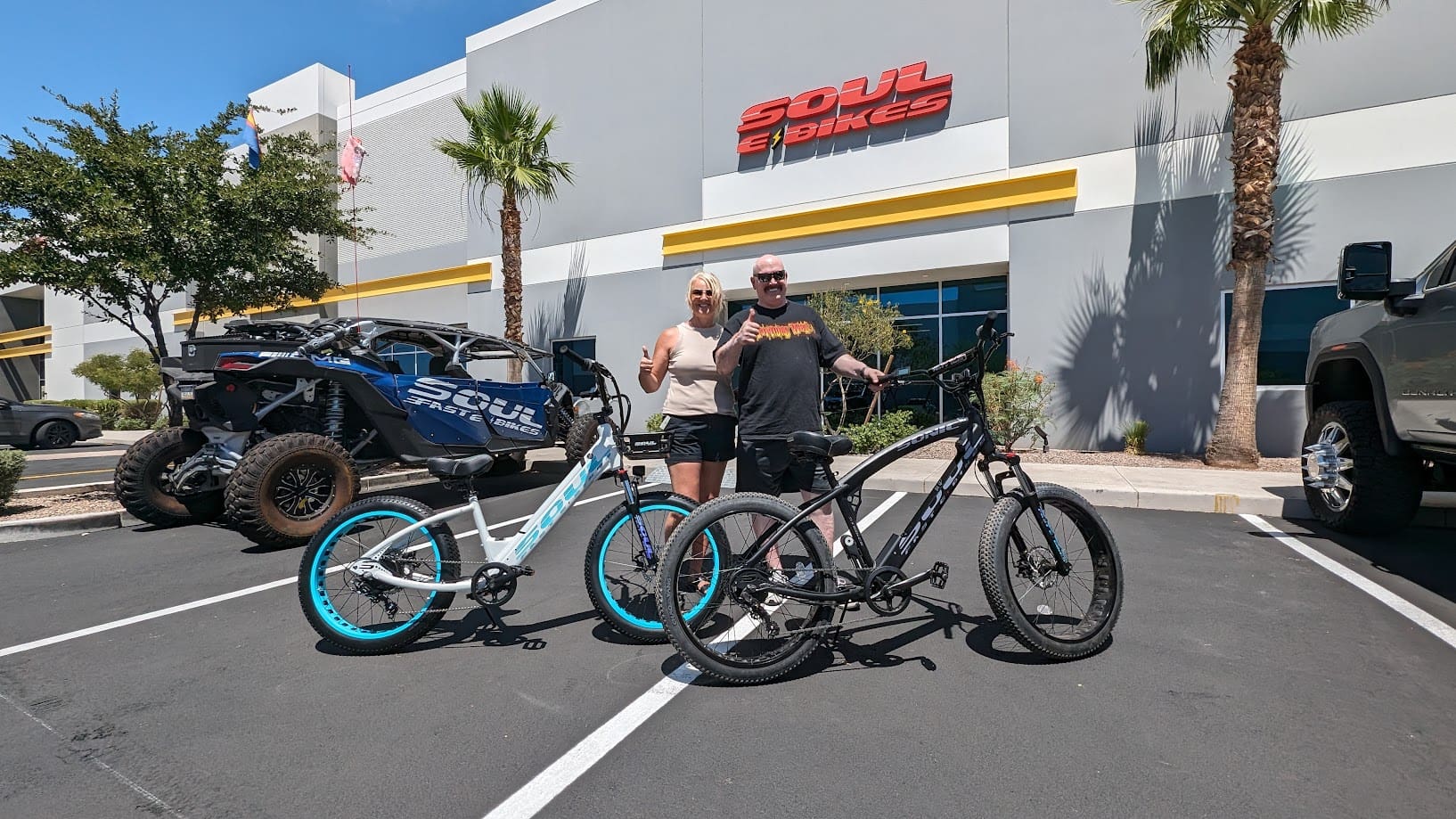 Two people with bicycles outside a store.