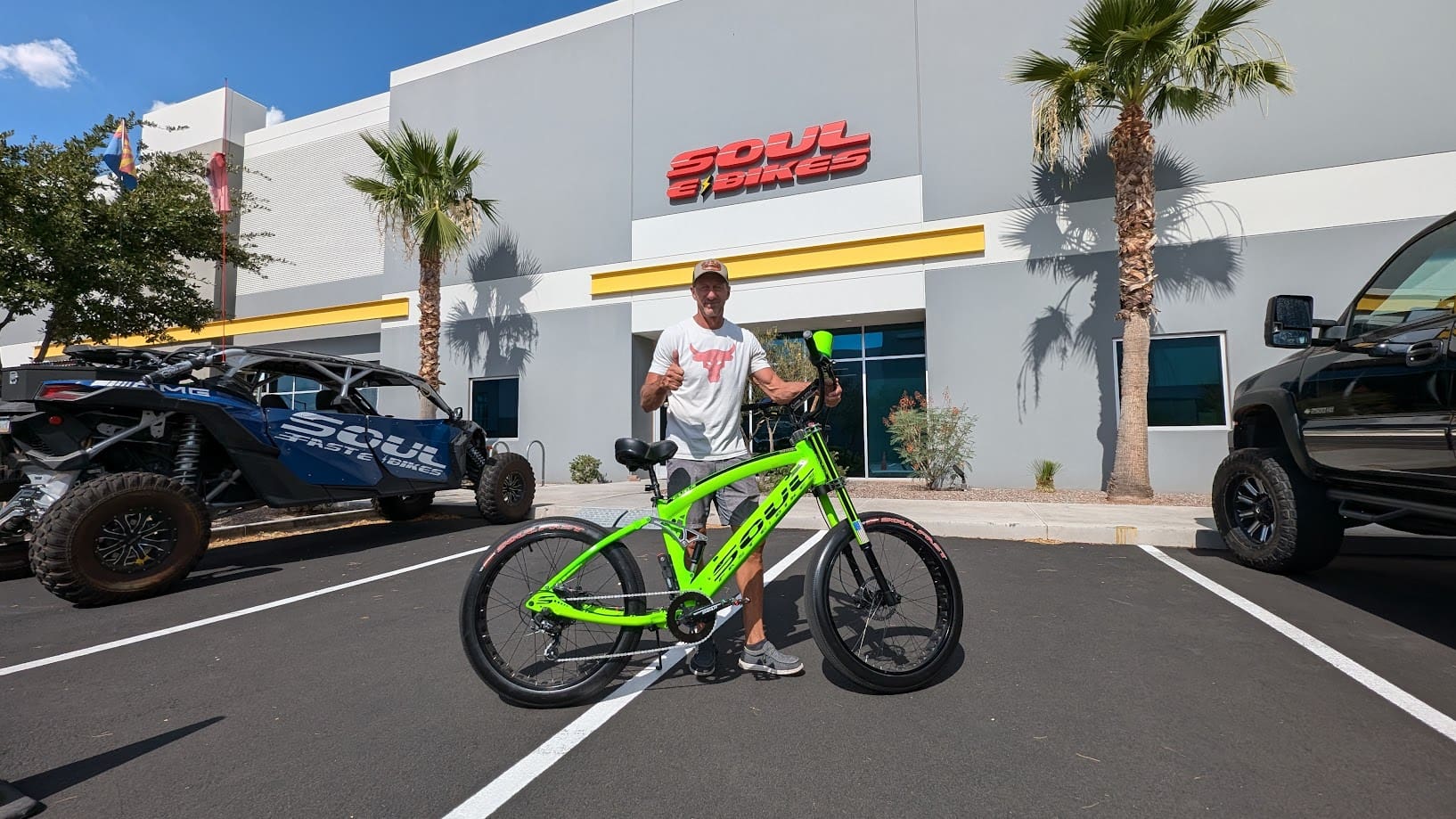 Person with green bike outside store building.