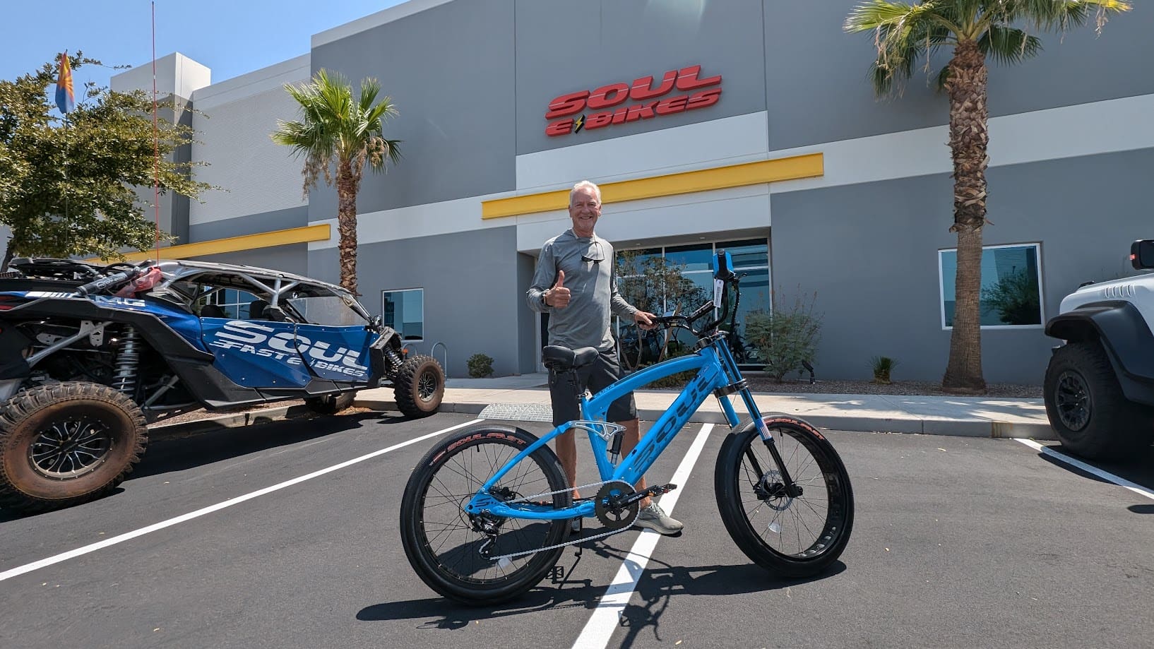 Man with bike in front of store.