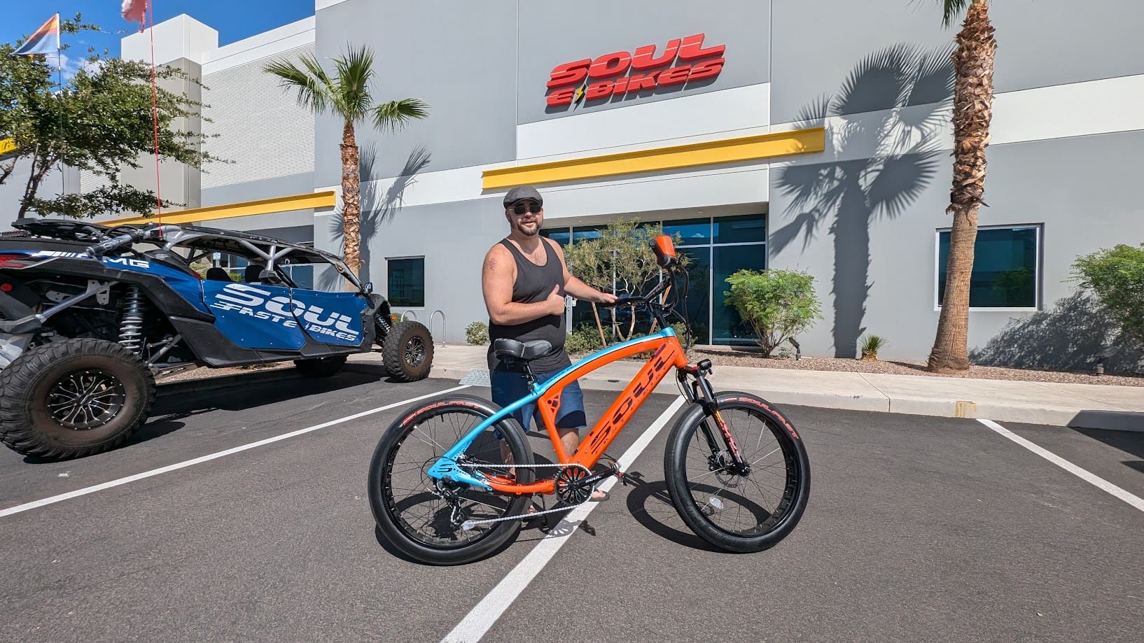 Man posing with an electric bicycle outside.