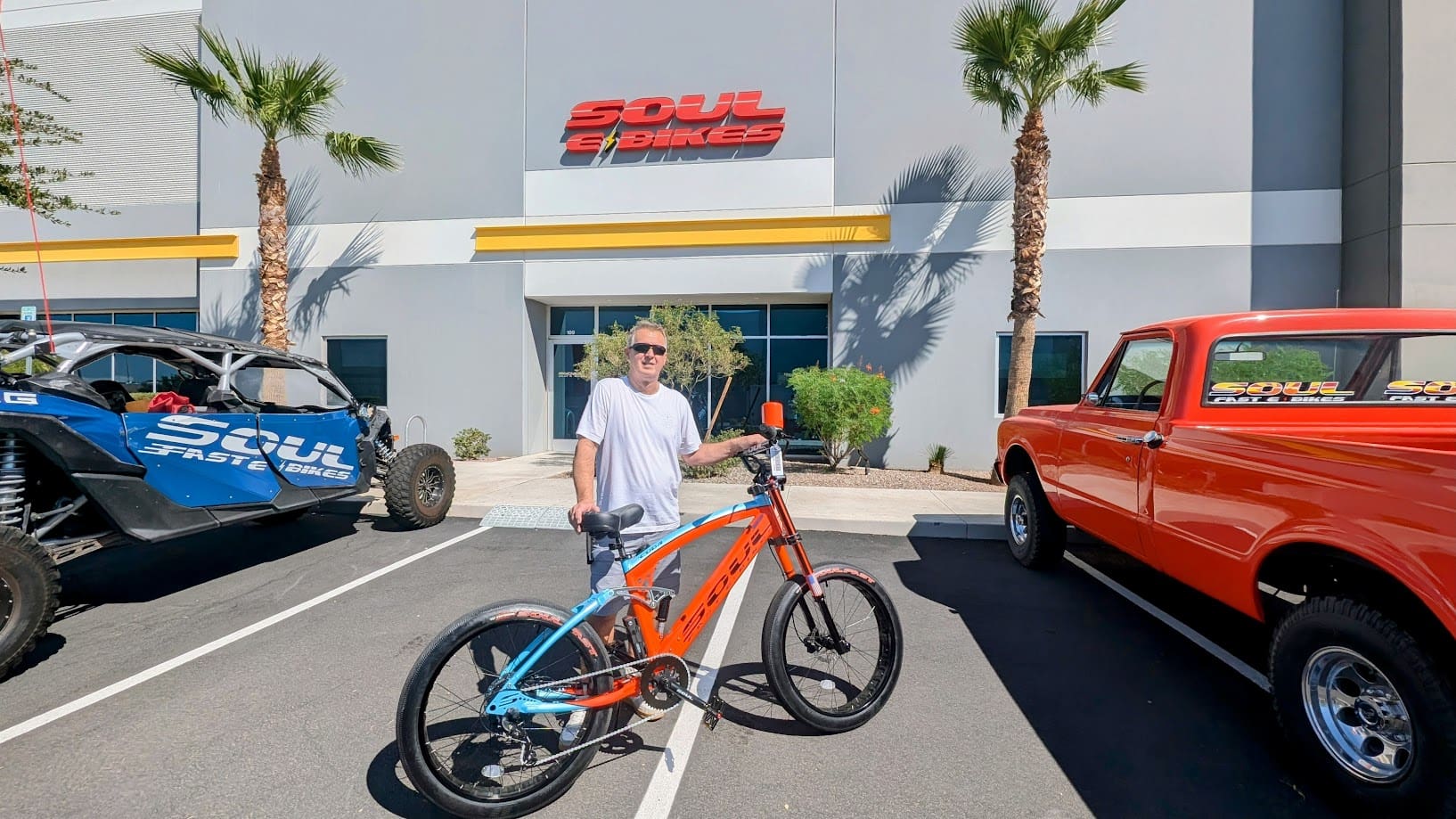 Person with bicycle outside Soul E Bikes store.