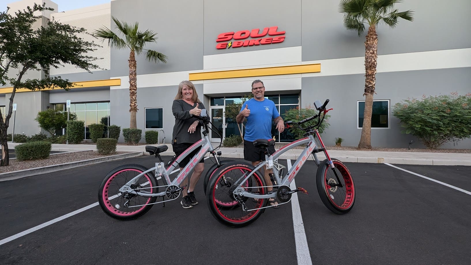 Two people with bikes outside a store.