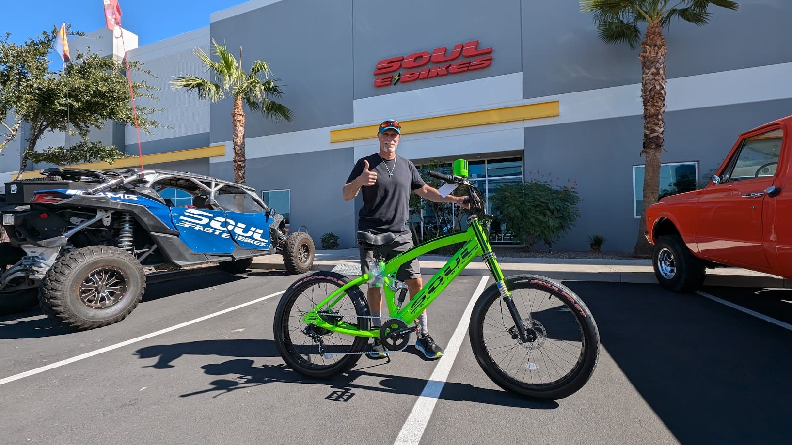 Man with green bike outside store.