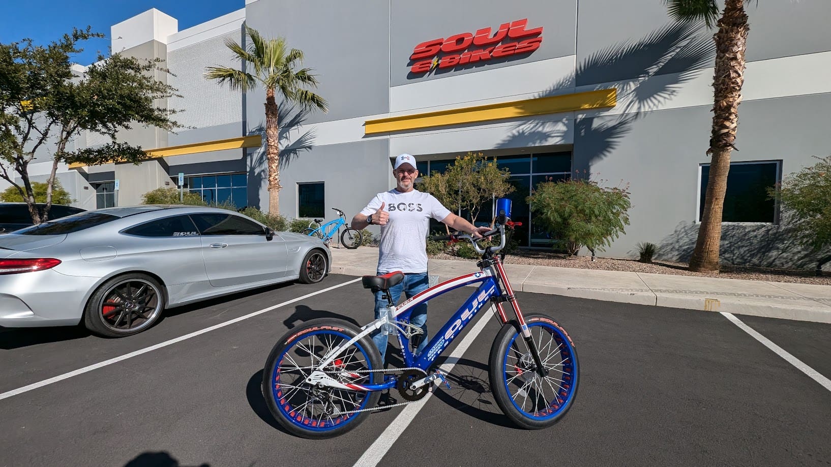 Man standing with bike outside building.