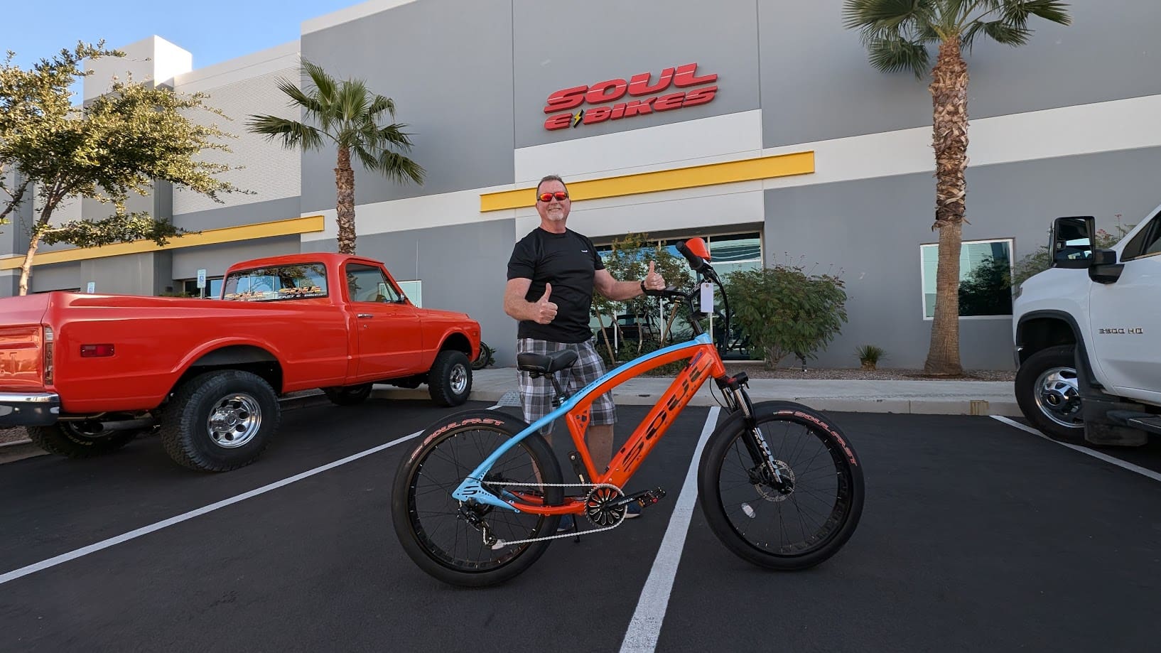 Man with bicycle outside Soul Beach Bikes store.