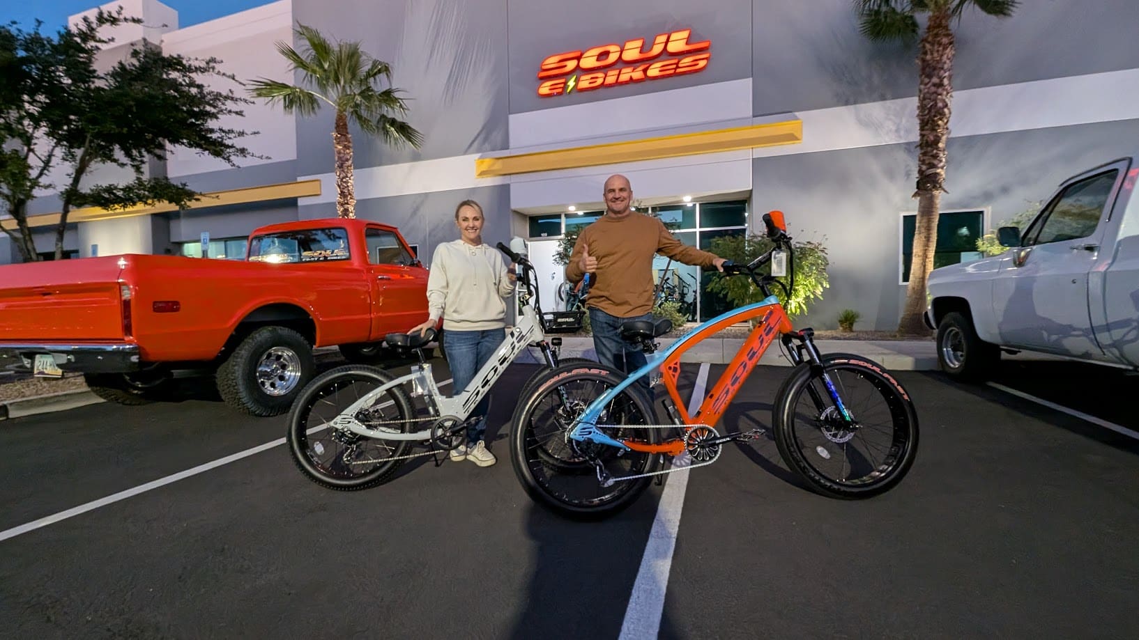 Two people with bicycles outside Soul eBikes.
