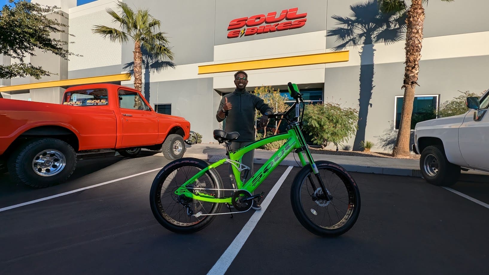 Man with green bike outside building.